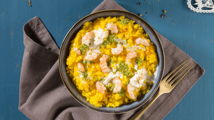 Risotto allo zafferano con gamberoni, crema di basilico, liquirizia e stracciatella